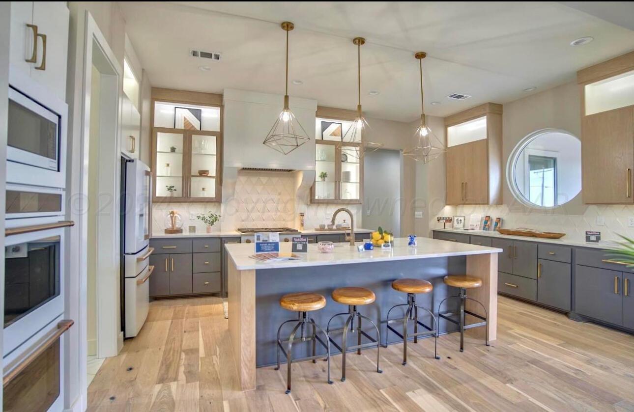 19181 Buck Springs Road Amarillo, TX 79119 - Photo 30 of 86 a large kitchen with kitchen island a island a sink a stove and a wooden floor