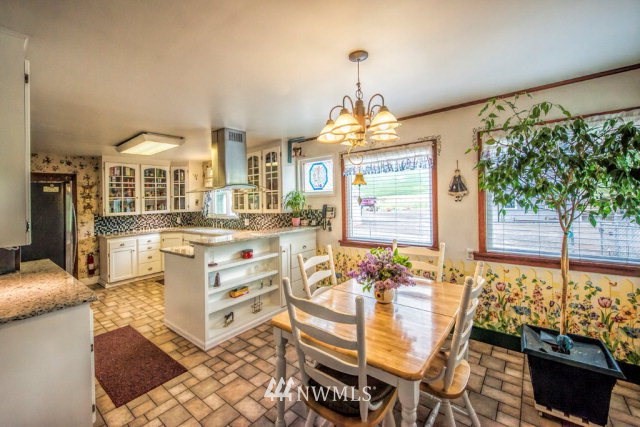 9590 Smith Springs Road Prescott, WA 99348 - Photo 2 of 40 a view of a dining room with furniture a chandelier and large windows