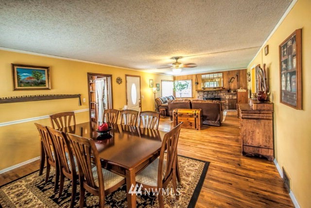 9590 Smith Springs Road Prescott, WA 99348 - Photo 3 of 40 a view of a dining room with furniture one side kitchen view and wooden floor