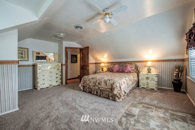 9590 Smith Springs Road Prescott, WA 99348 - Photo 5 of 40 a spacious bedroom with a bed and a chandelier