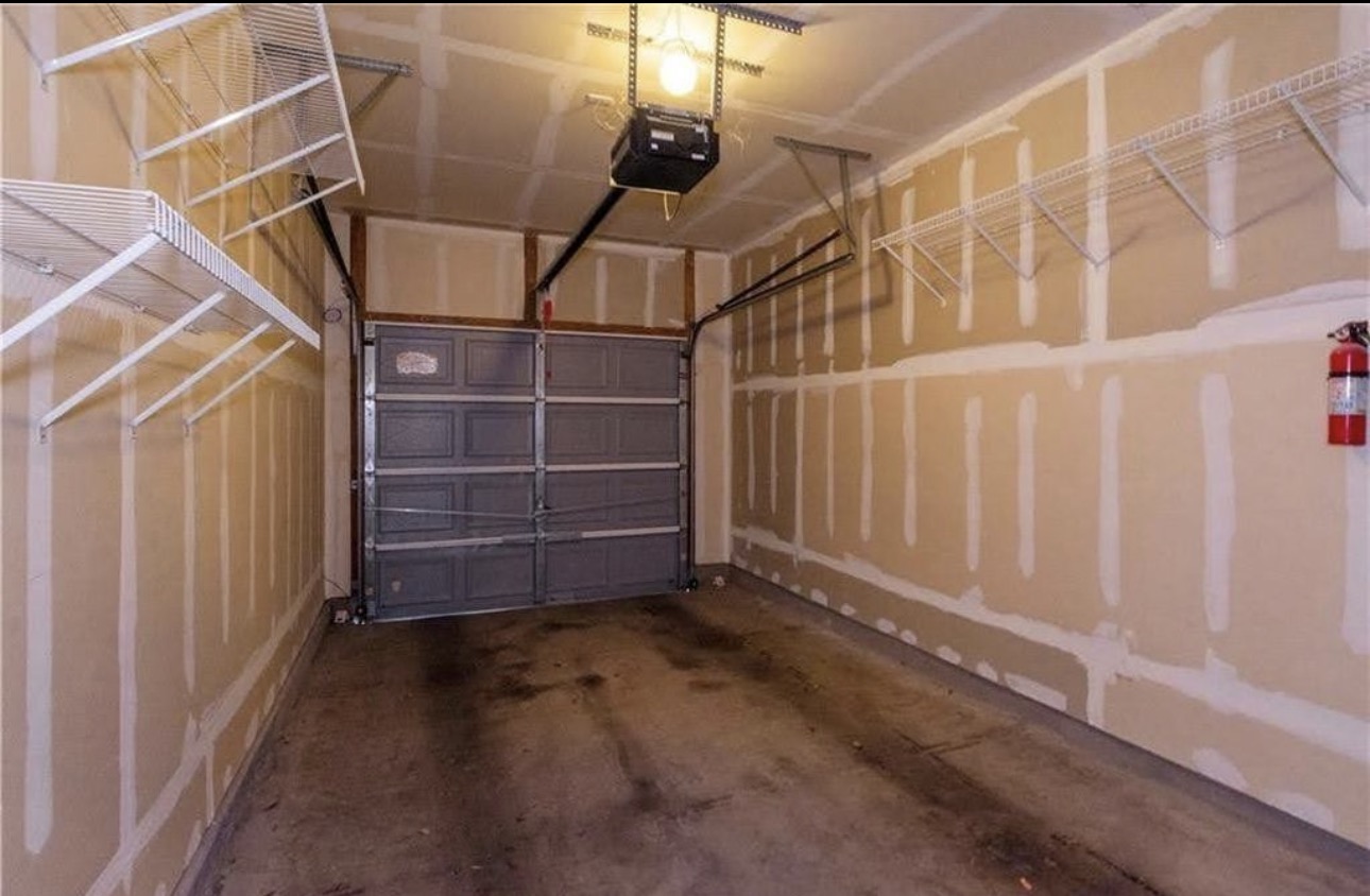 1900 Scofield Ridge Parkway, Unit 3101 Austin, TX 78727 - Photo 23 of 24 Single-car garage featuring a sectional garage door, concrete flooring, automatic garage door opener, and integrated wire shelving