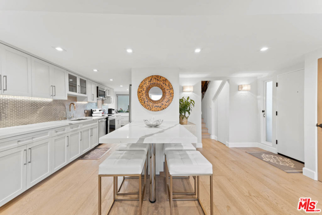 23910 De Way, Unit C Malibu, CA 90265 - Photo 19 of 45 a kitchen with a dining table cabinets and wooden floor