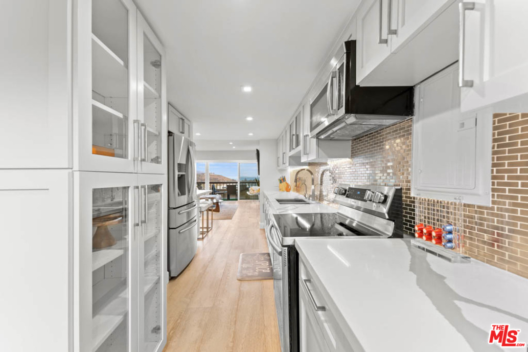 23910 De Way, Unit C Malibu, CA 90265 - Photo 21 of 45 a kitchen with stainless steel appliances kitchen island granite countertop lots of counter top space