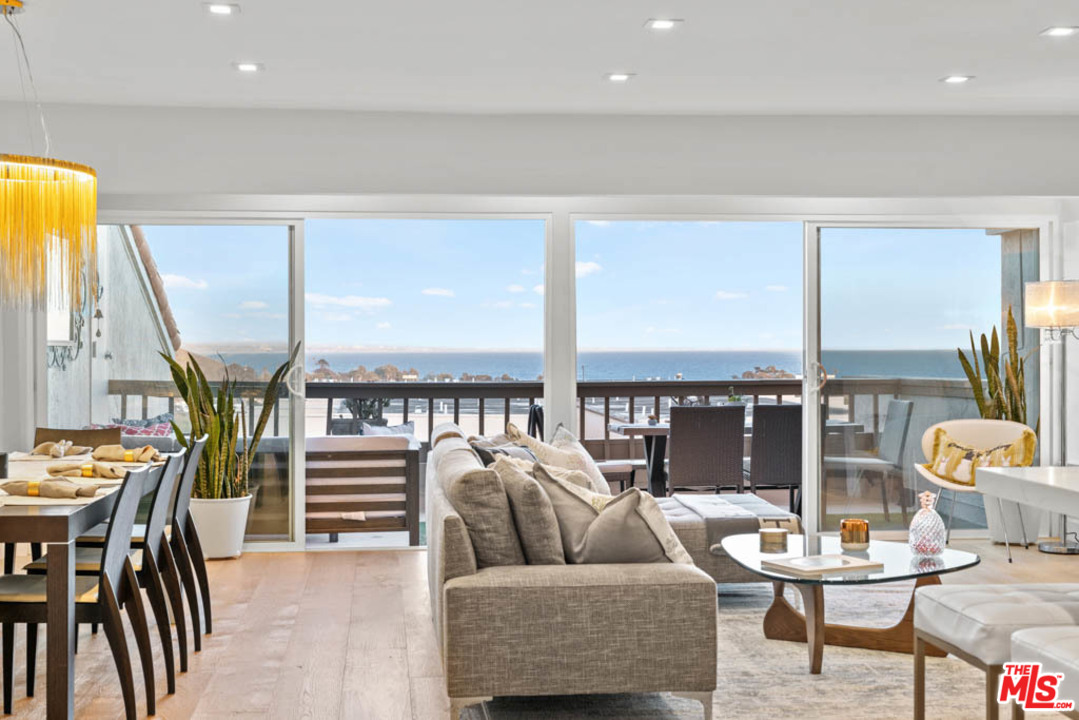 23910 De Way, Unit C Malibu, CA 90265 - Photo 26 of 45 a living room with furniture and a floor to ceiling window