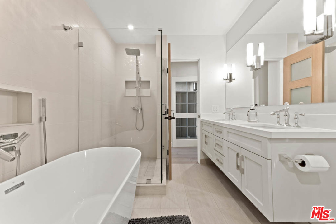 23910 De Way, Unit C Malibu, CA 90265 - Photo 29 of 45 a bathroom with a double vanity sink a large mirror and a bathtub