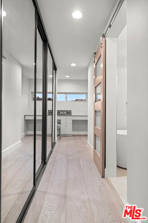 23910 De Way, Unit C Malibu, CA 90265 - Photo 41 of 45 a view of a hallway with wooden shelves