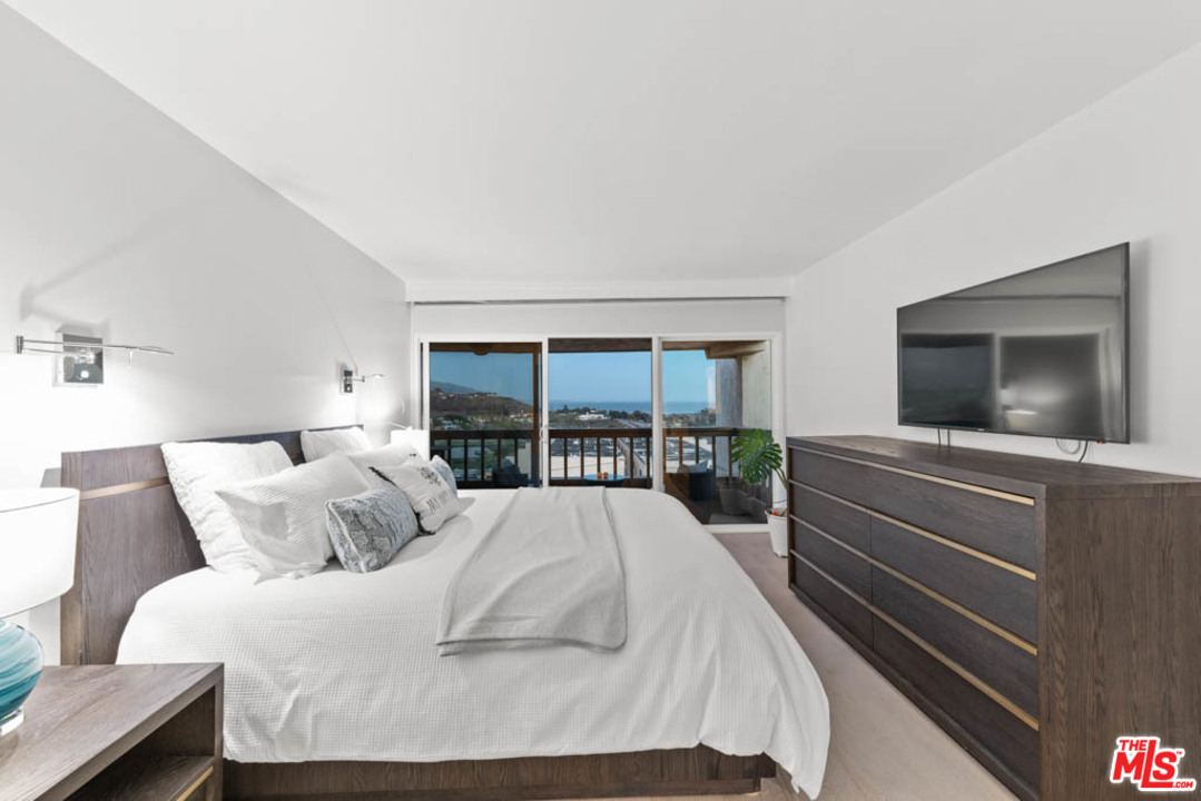 23910 De Way, Unit C Malibu, CA 90265 - Photo 45 of 45 a bedroom with a large bed and a flat screen tv