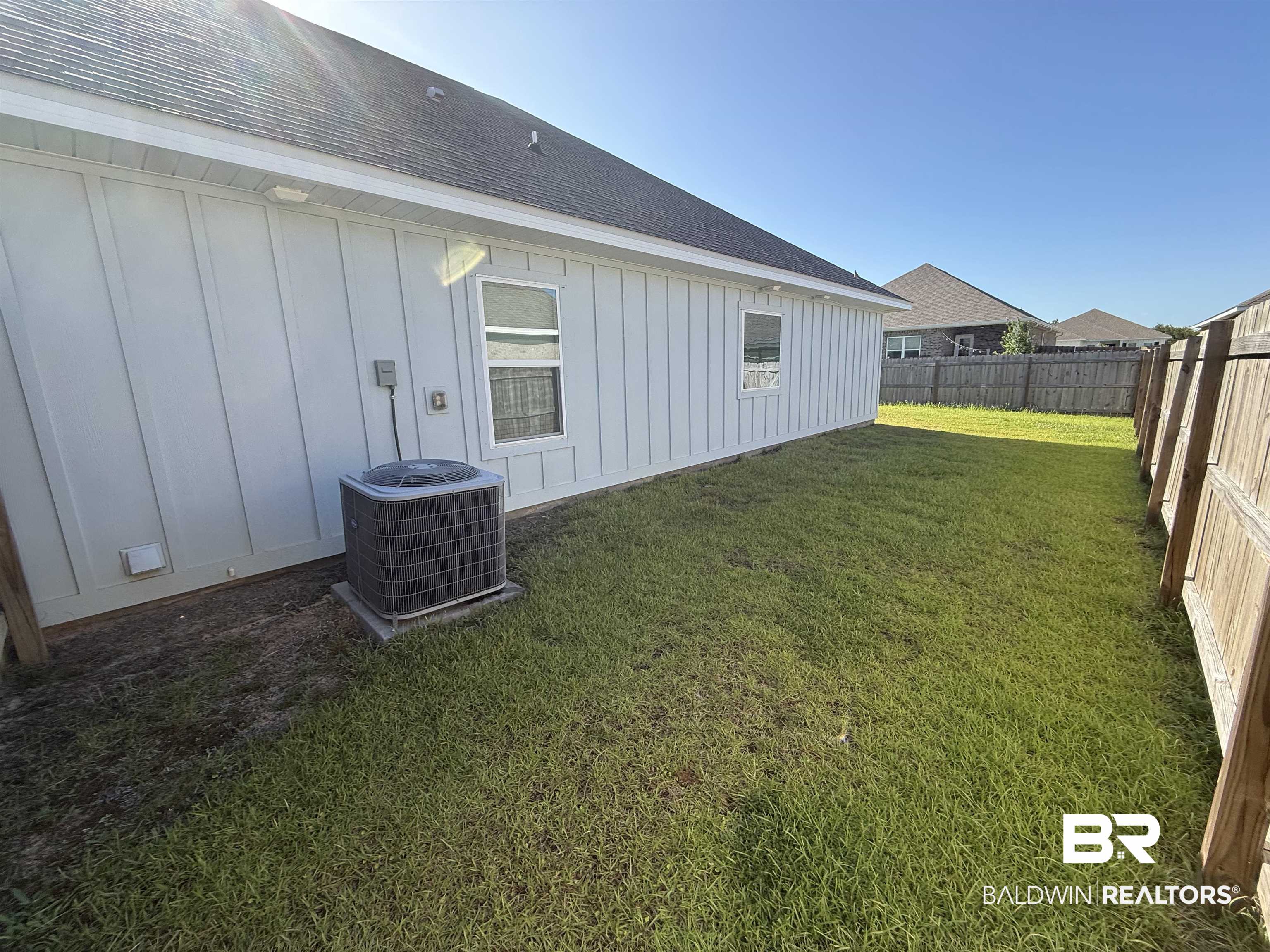 23247 Lieutenant Avenue Foley, AL 36535 - Photo 43 of 47 Side yard with board and batten siding, a dark shingle roof, and a wooden privacy fence
