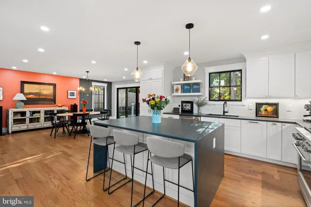 a kitchen with stainless steel appliances granite countertop table chairs and a chandelier