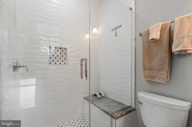 a bathroom with a granite countertop sink a toilet and shower