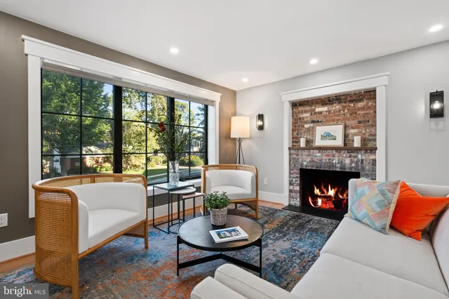a living room with furniture a fireplace and a large window