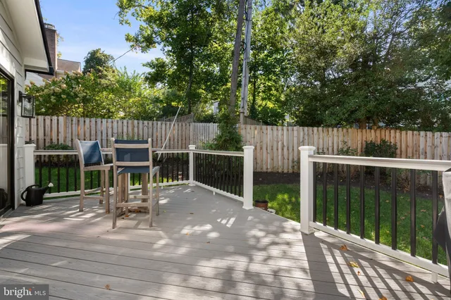 a view of a deck with chairs and wooden fence