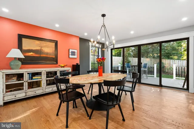 a dining room with furniture a chandelier and wooden floor