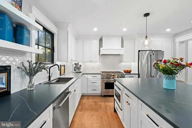 a kitchen with kitchen island a sink stove and refrigerator