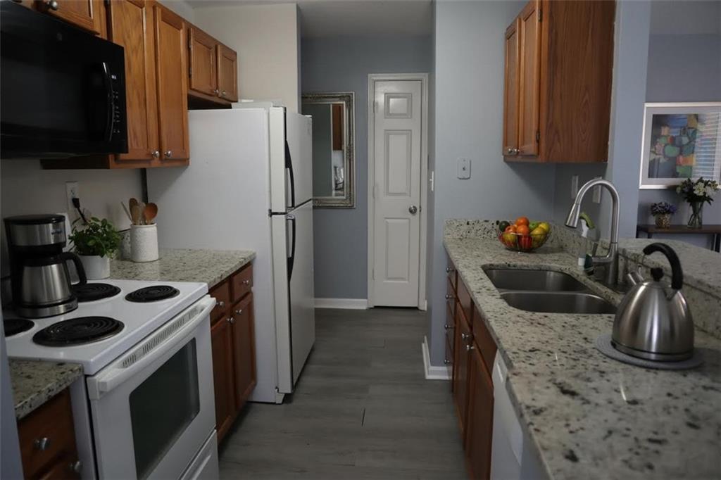 1103 Garden Court Atlanta, GA 30328 - Photo 2 of 17 a kitchen with stainless steel appliances granite countertop a sink stove and refrigerator