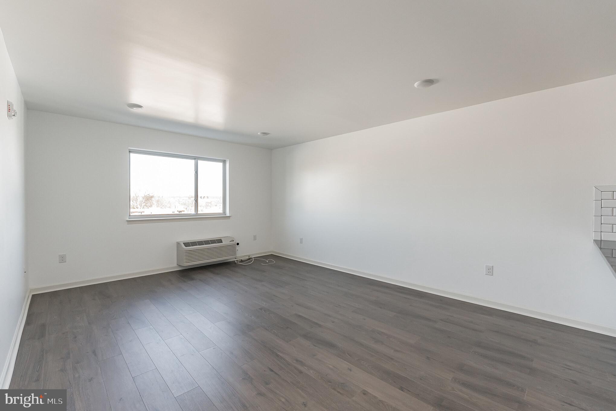 6649 Ridge Avenue, Unit B403 Philadelphia, PA 19128 - Photo 7 of 9 an empty room with wooden floor and windows