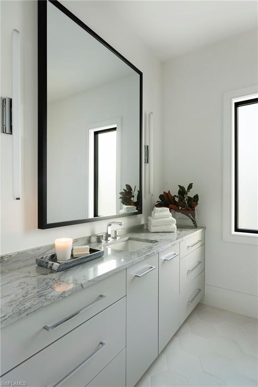 6704 Newport Road Naples, FL 34109 - Photo 27 of 47 a bathroom with a granite countertop sink a mirror and a