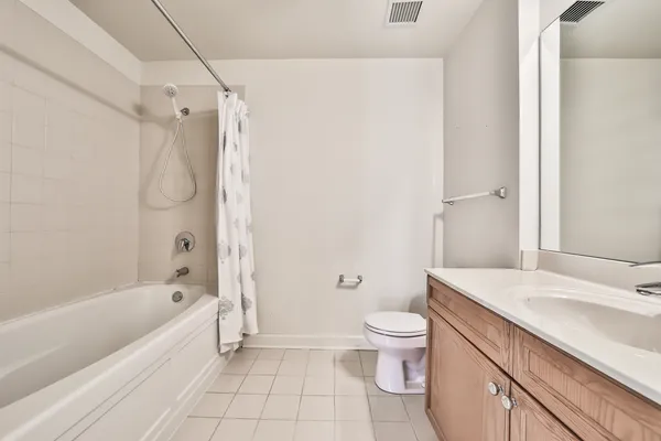a bathroom with a granite countertop sink a toilet and shower