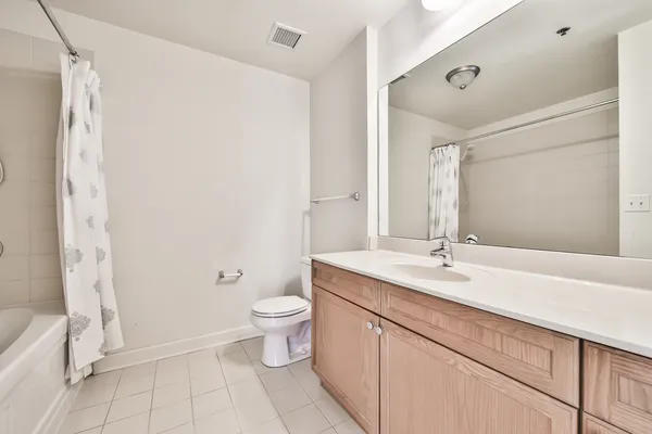 a bathroom with a granite countertop sink mirror vanity and toilet