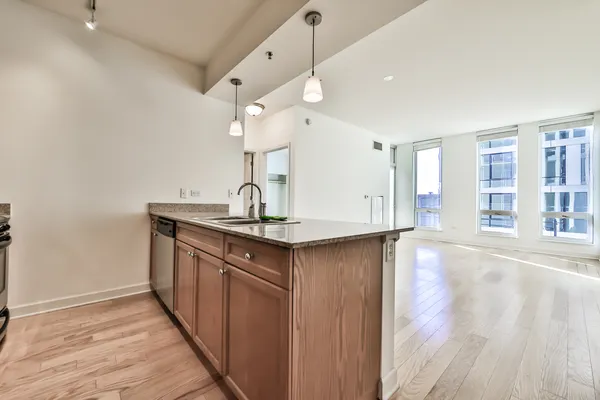a kitchen with stainless steel appliances granite countertop a sink and wooden floor
