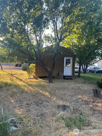 a view of a house with backyard and tree