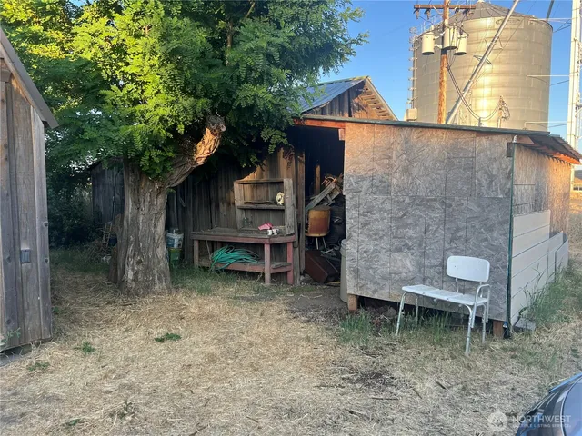 a backyard of a house with table and chairs a barbeque