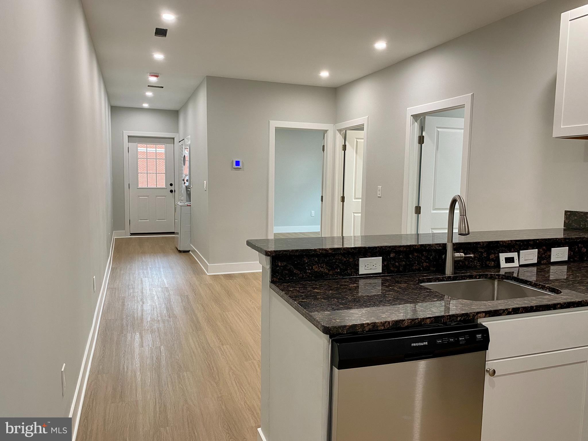 a kitchen with granite countertop a sink and wooden floor