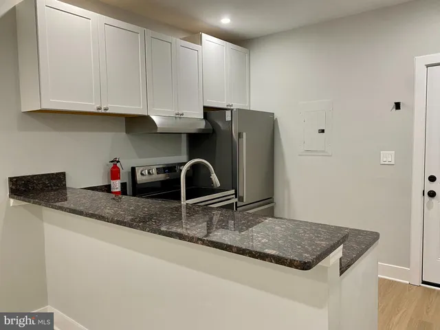 a kitchen with stainless steel appliances granite countertop a sink refrigerator and cabinets