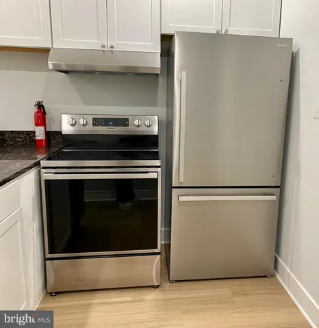 a stove top oven sitting inside of a kitchen