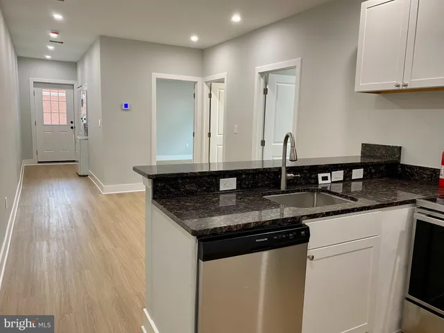 a kitchen with granite countertop a sink and cabinets