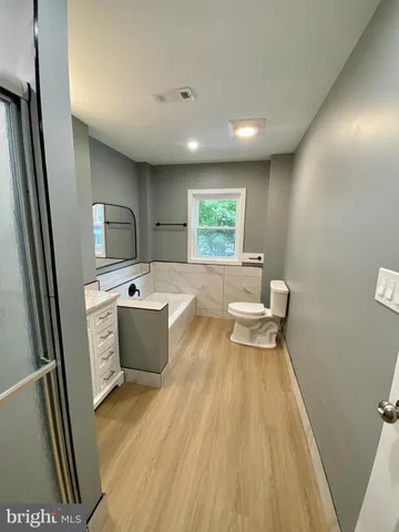a bathroom with a sink a toilet a window and tub