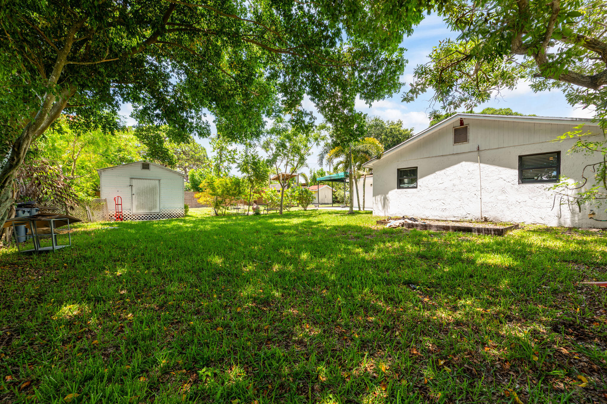 1216 Neoga Street Jupiter, FL 33458 - Photo 20 of 27 a front view of house with yard and green space