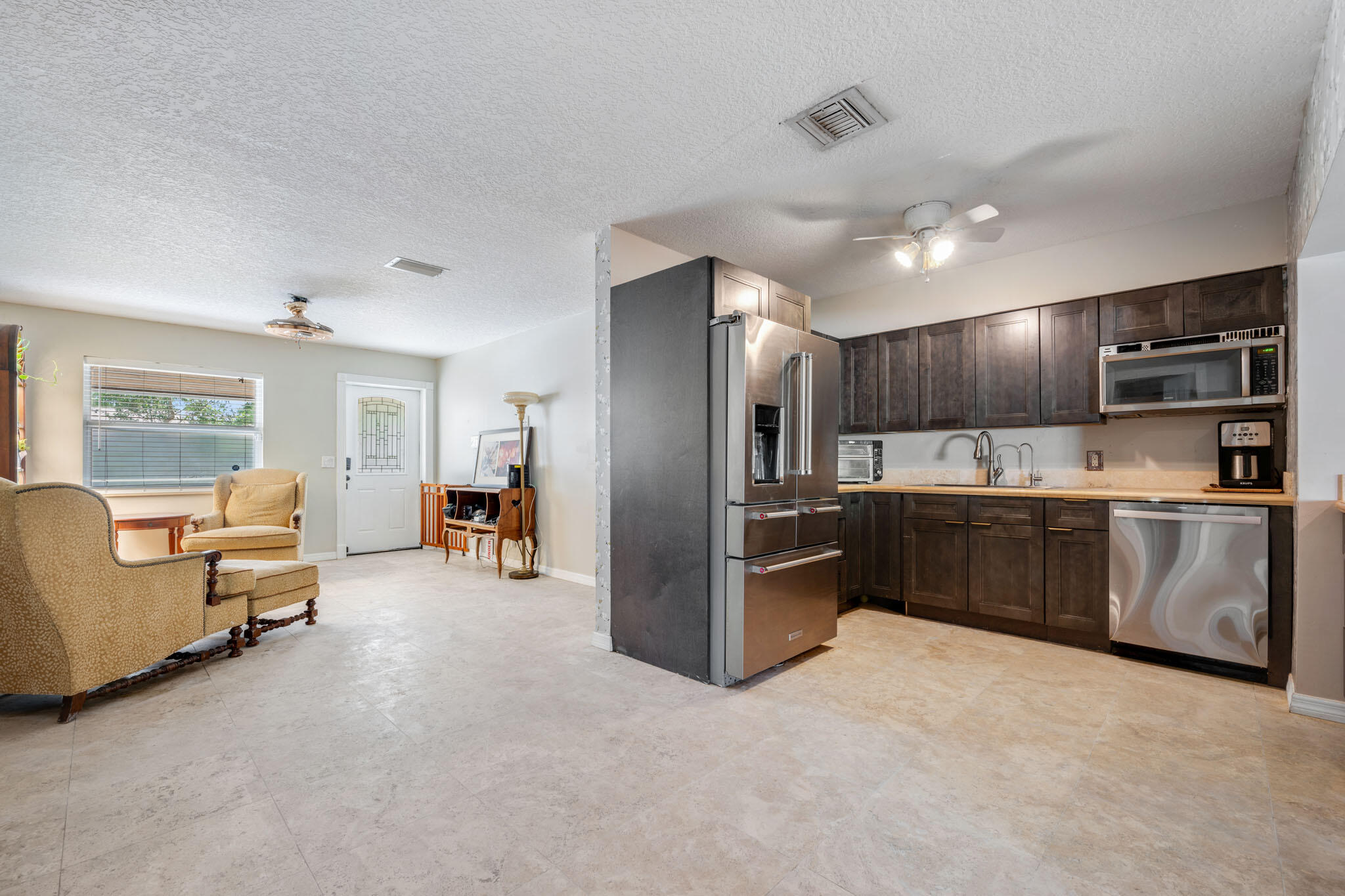 1216 Neoga Street Jupiter, FL 33458 - Photo 6 of 27 a kitchen with stainless steel appliances kitchen island granite countertop a refrigerator and a sink