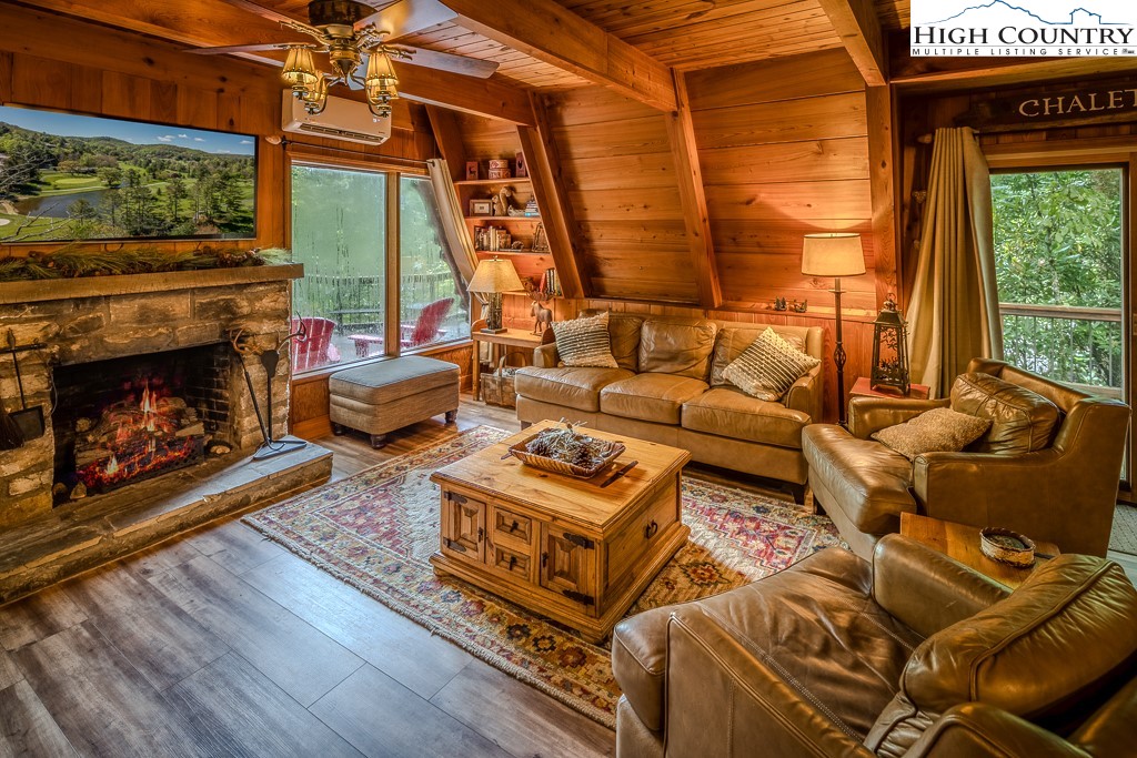 268 Cherry Drive Boone, NC 28607 - Photo 2 of 33 a living room with furniture a fireplace and a floor to ceiling window
