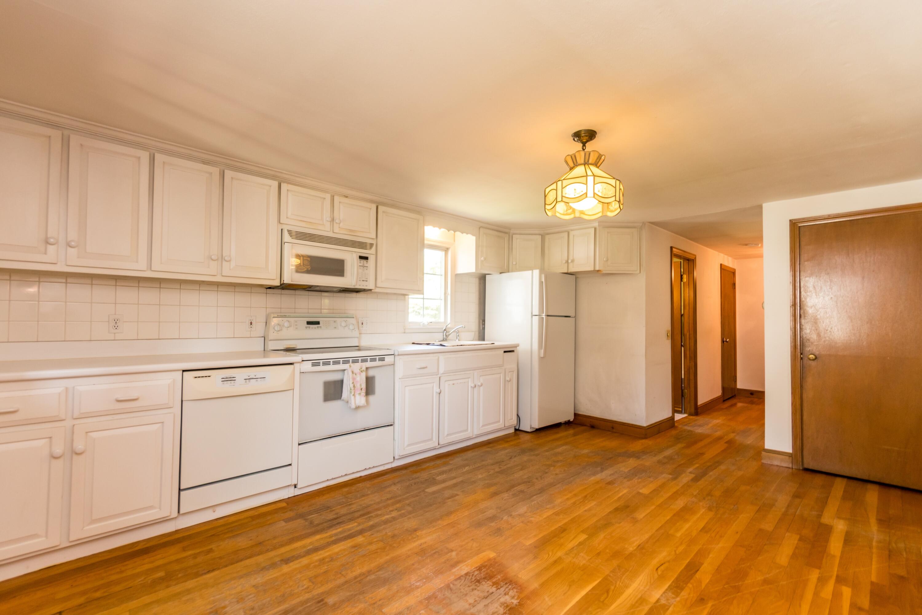 14 Ahab Road Yarmouth Port, MA 02675 - Photo 10 of 36 a kitchen with granite countertop a refrigerator a stove a sink and white cabinets with wooden floor