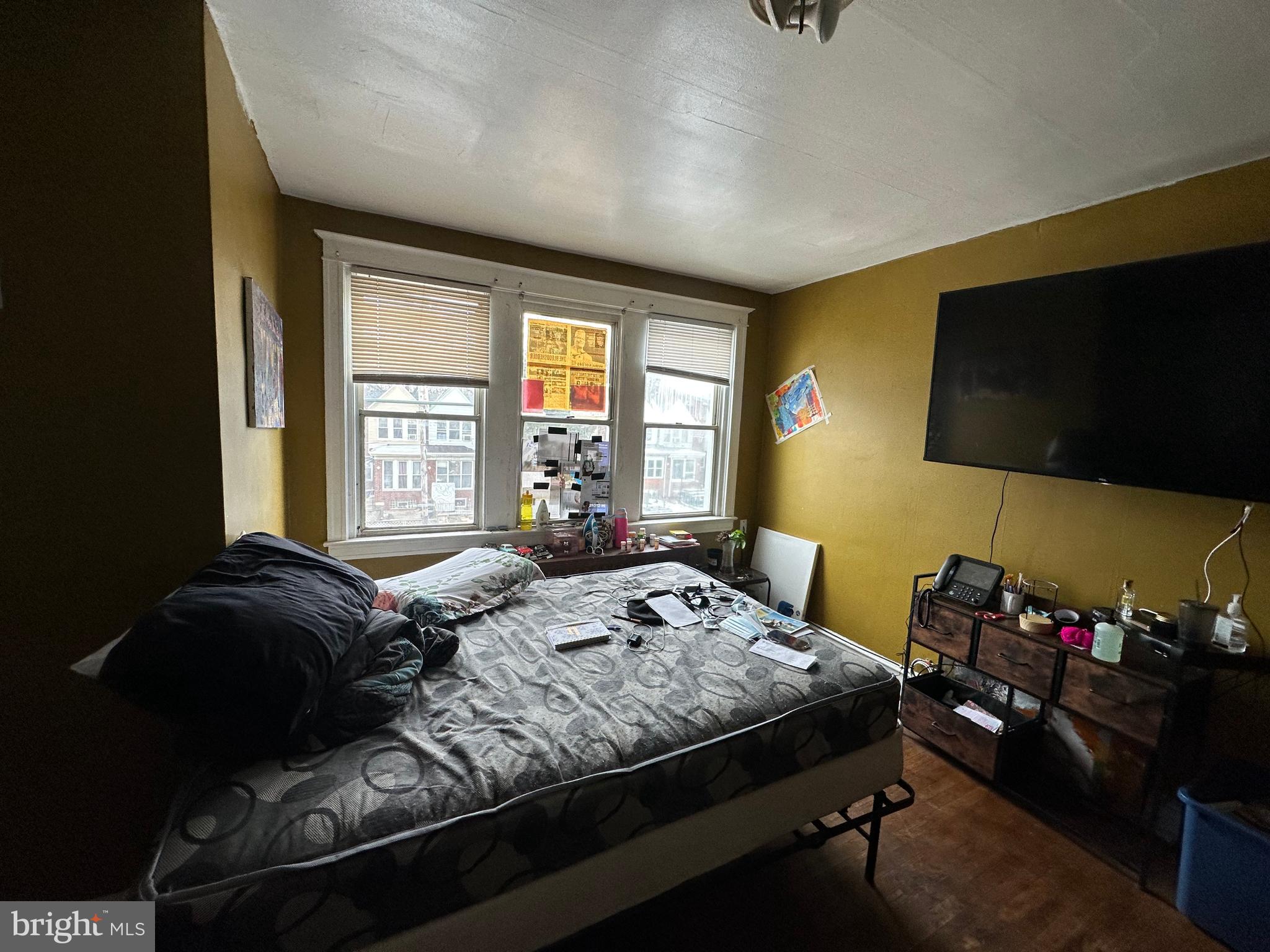 5039 F Street Philadelphia, PA 19124 - Photo 5 of 14 a bedroom with a bed a flat screen tv and windows