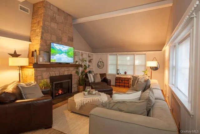 a living room with furniture a large window and wooden floor