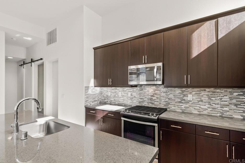 2012 Foxtrot Loop, Unit 3 Chula Vista, CA 91915 - Photo 8 of 34 a kitchen with stainless steel appliances granite countertop a sink stove and cabinets