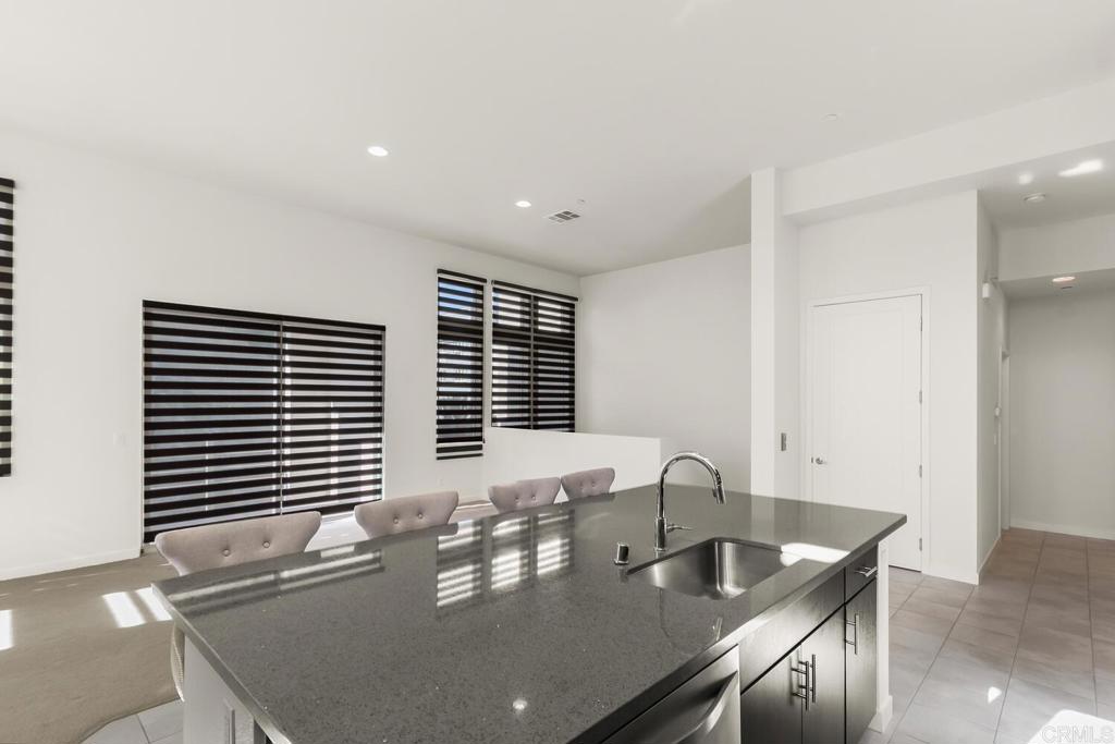 2012 Foxtrot Loop, Unit 3 Chula Vista, CA 91915 - Photo 9 of 34 a dining room with kitchen island granite countertop a sink and wooden cabinets