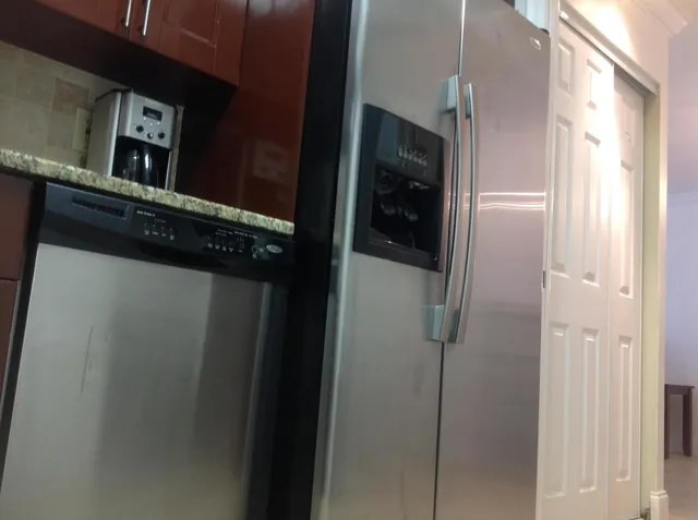 a kitchen with stainless steel appliances granite countertop a refrigerator and a sink