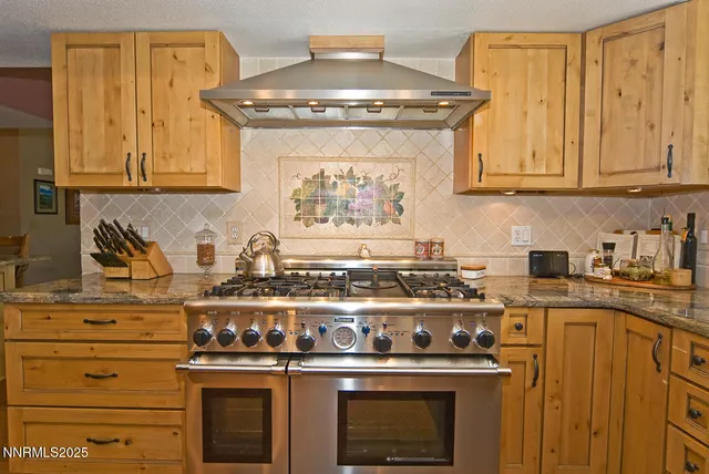 a kitchen with stainless steel appliances a refrigerator and wooden floor