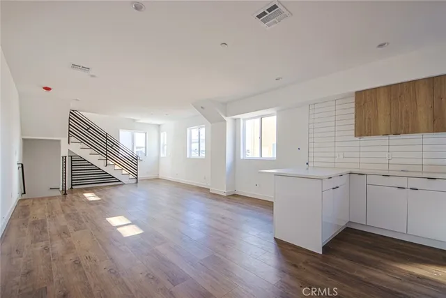a view of a kitchen with wooden floor and a sink