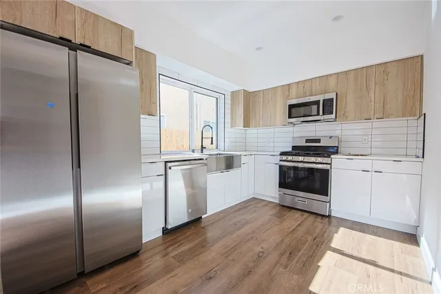 a kitchen with a refrigerator and a stove top oven