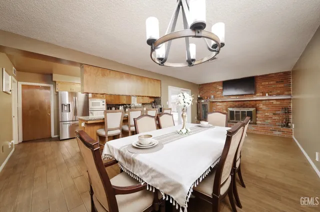 a dining room with furniture a chandelier and wooden floor