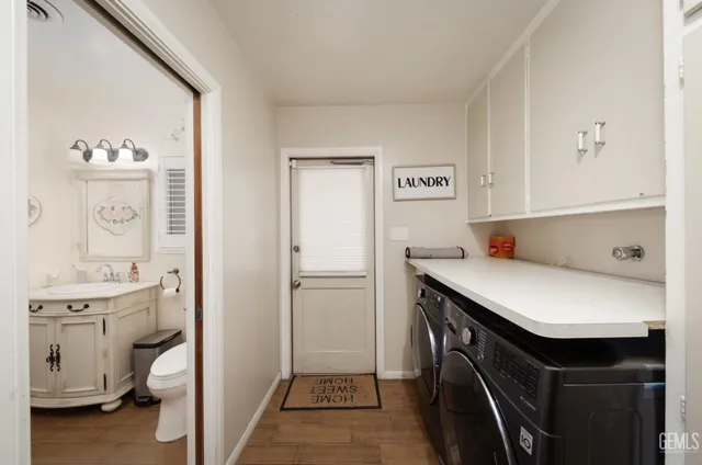 a utility room with cabinets washer and dryer