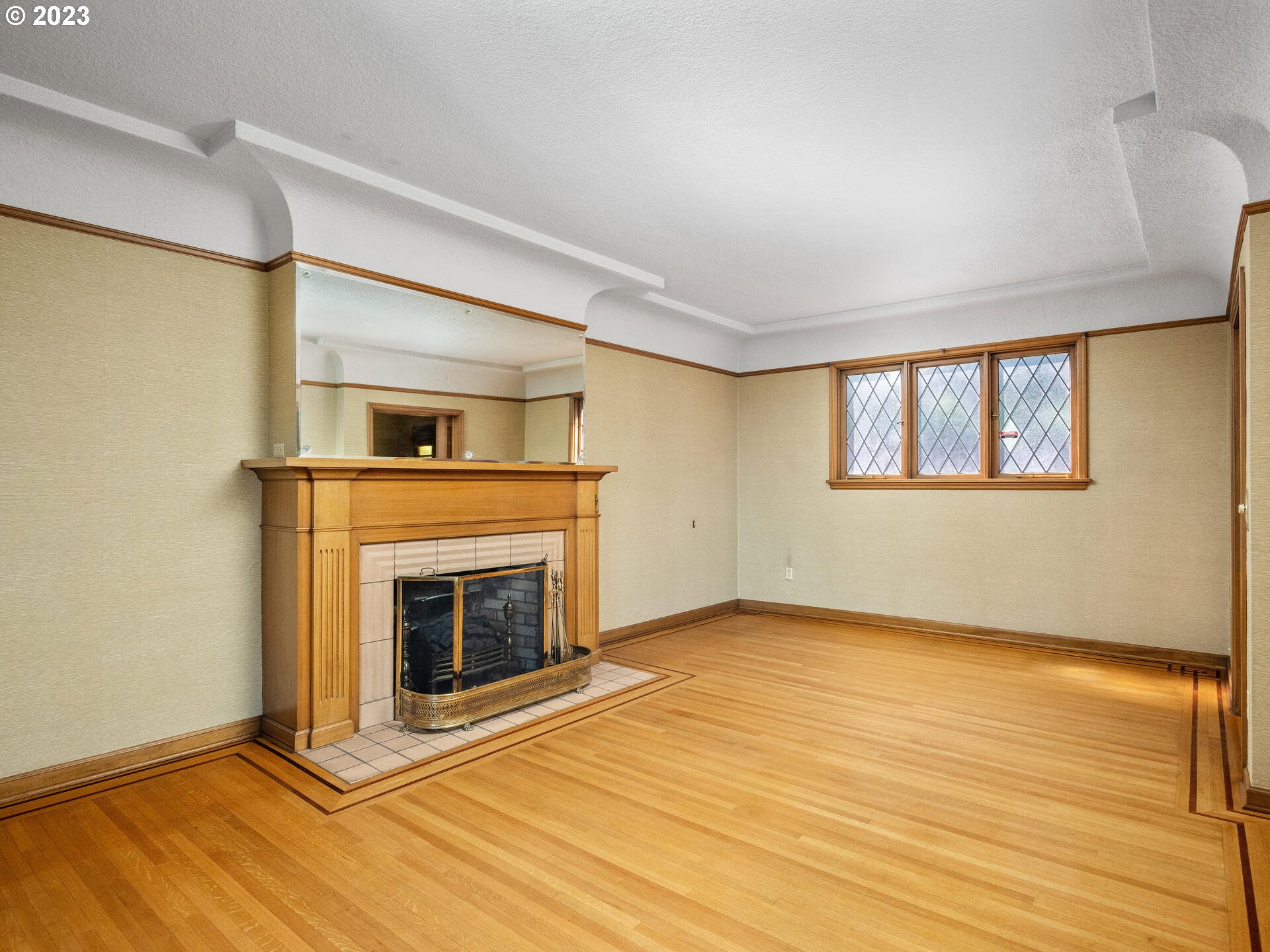 1442 Southwest Vista Avenue Portland, OR 97201 - Photo 6 of 46 a view of an empty room with wooden floor fireplace and a window