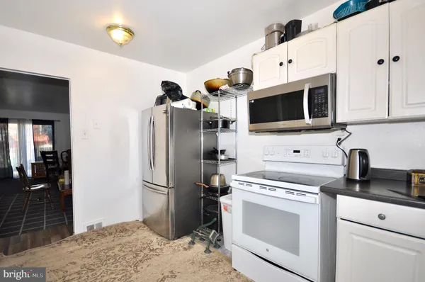 a kitchen with stainless steel appliances granite countertop a refrigerator a stove and a sink with wooden floor