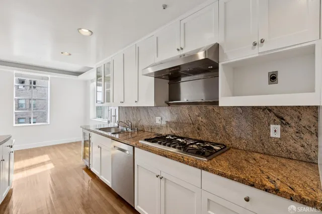 a kitchen with stainless steel appliances granite countertop a sink stove and cabinets