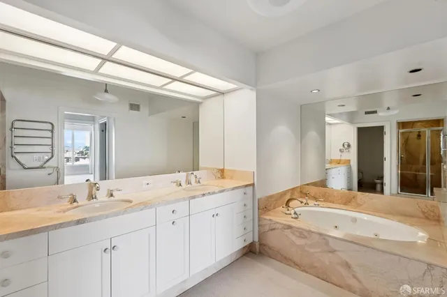 a spacious bathroom with a double vanity sink and mirror