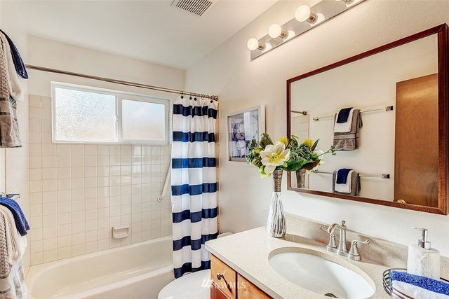 a bathroom with a granite countertop sink a toilet and shower